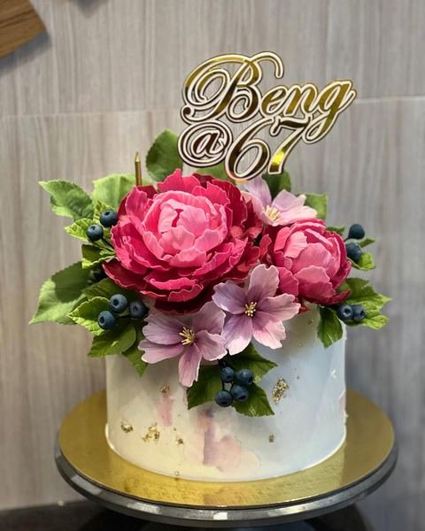 Birthday cake with a floral peonies and blueberries theme
