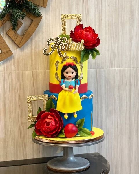 Birthday cake with a red yellow blue princess snow theme