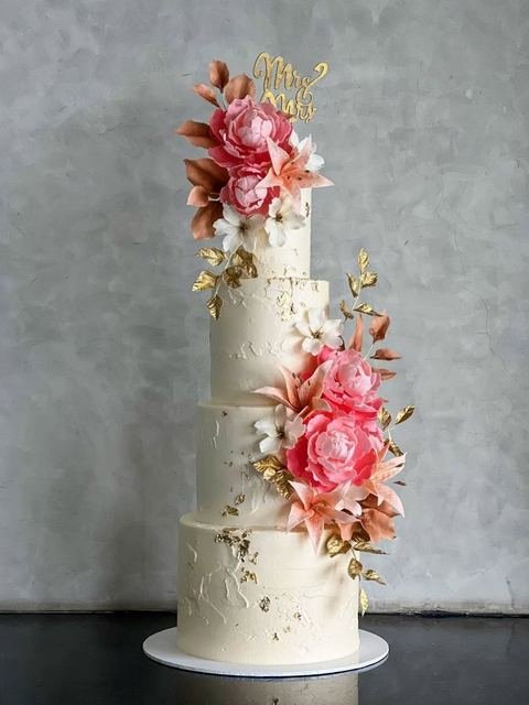 Four tier white wedding cake with sugar flowers